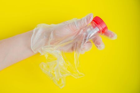 Hand in latex glove holds one broken plastic bottle. No waste and recycle conceptの写真素材