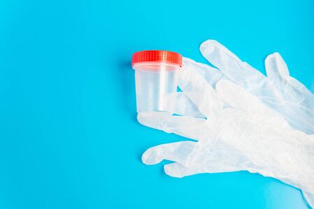 Flat lay of the medical latex gloves and empty plastic test container with copy spaceの写真素材