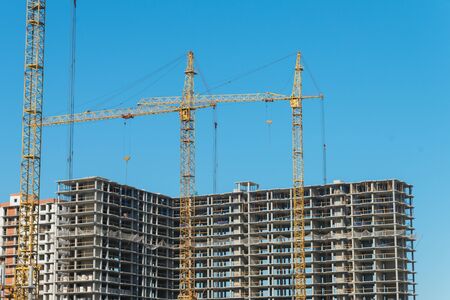 Two construction cranes near the unfinished buildings. Construction and developing conceptの写真素材