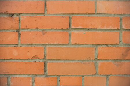 Orange bricks wall closeup background. Stained old brick wall texture.の写真素材