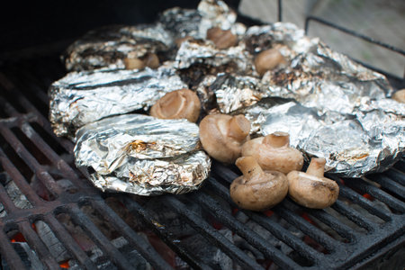 Mushroom and meat in the foil on the grill. Weekend and picnic. High quality photoの写真素材