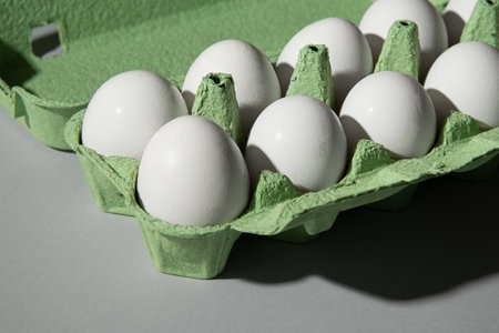 Cardboard green egg box on a gray background, a lot of eggs are in the box.の写真素材