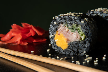 Black rice. Rolls with cheese, ham, and cucumber. Sticks and ginger are licked near the land.の写真素材