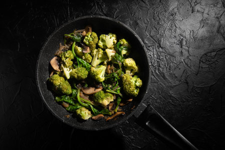Dish Fried vegetables with mushrooms in a non-stick pan. Broccoli, spinach, onion in olive oil. Cooking healthy food.の写真素材