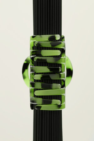 Hair accessory. Green hairpin on a light beige background.