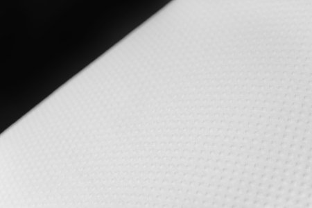 Texture of a white square paper towel on a black background.