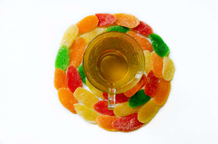 Green tea in glass cup with sweets - candied pineapple on white background. located in the middleの写真素材
