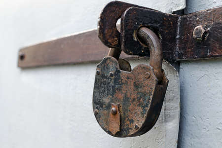 Old rusty but reliable barn door lock - the concept of prohibition or protectionの写真素材
