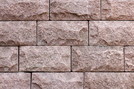 Facing bricks dirty pink color close up. Ragged Stone Texture.
