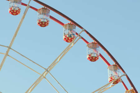 An attraction of a Ferris wheel against a blue sky background. The cabin of Ferris wheels closeup.の写真素材