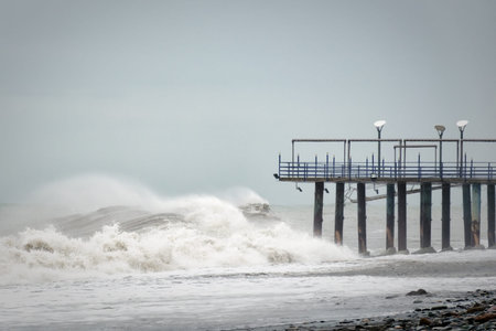 Storm waves on the sea are broken about the pier.