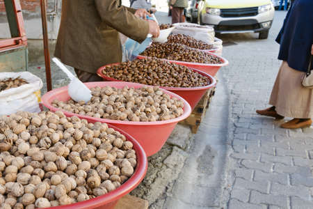 Walnuts and chestnuts are selling on the street in the Turkish village in large plastic bowl.の写真素材