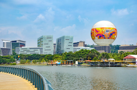 Cyberjaya, Selangor, Malaysia, 02/23/2018: Modern city landscape - attraction flying in hot air balloon in Skyrides Festivals Park Putrajaya with view of lake and modern skyscrapers. Entertainment of city dwellers.のeditorial素材