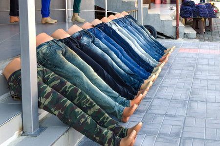 Mannequins in the form of legs, dressed in jeans lie, laid out at srairs in line. Concept of  alike, equally, similarity.の写真素材