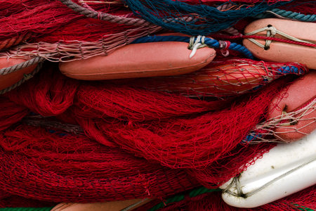 Fishing nets with floats. Rope texture, Background with blue and red nettingの写真素材