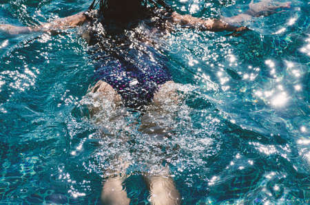 Blurred photo of woman swims in the pool. Rear view from the back.  Summer holiday concept.の写真素材