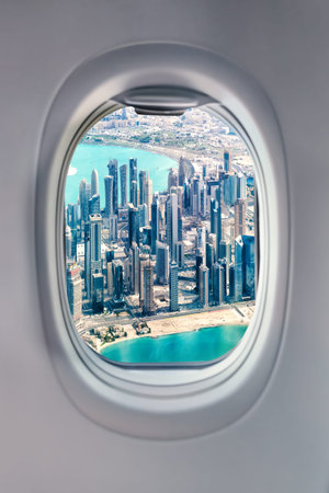 View from airplane window at Doha skyscrapers. Planes and cities concept.