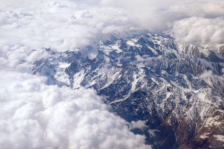 Aerial view of the mountain ranges. View through the clouds to the mountain peaks. Fantastic...
