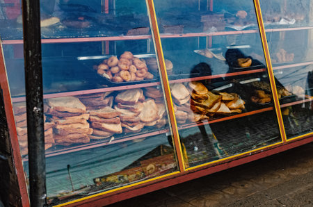 Half-empty bakery showcase with leftover bread, pastries.  Dirty and messy. Sri Lanka, Weligama.の写真素材