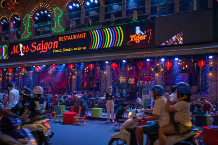 Walking street Bui Vien during lockdown. People are relaxing on the open terrace in the night...