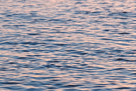 Tranquil sunset sea water surface. Soft blurred water ripple with sunny reflections. Defocused photo...