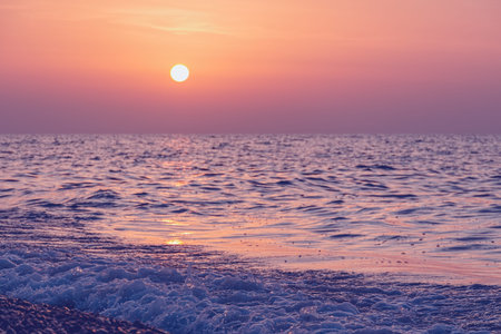 Vivid sunset over the sea water splash.  Evening peaceful landscape with summer beach. Defocused photo with blur in motion. Batumi, Georgiaの写真素材