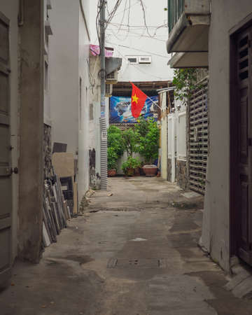Vietnamese tight residential street with a national flag at the end. Nha Trang, Vietnam: 2020-10-13のeditorial素材