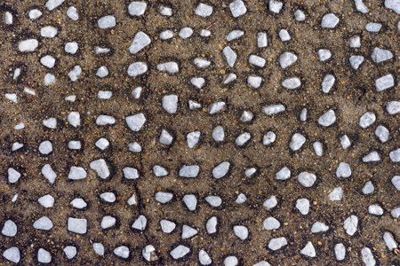 Tile small gray stones on brown background. Rough stone background for interior decor