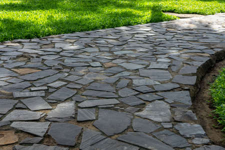 Grey cobblestone at the park walkway.  Garden footpath made of grey paving stoneの写真素材