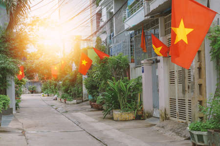 Flags along a small street in Hanoi. National Vietnamese flags set in houses narrow residential lane. Patriotism of citizens during the celebration of Vietnam National Dayのeditorial素材