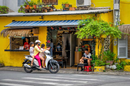 Traditional Vietnamese cafe with a roadside terrace, decorated with flowers. Visitors spend time in the restaurant. Photo with blur in motion. Nha Trang, Vietnam: 2020-10-23のeditorial素材