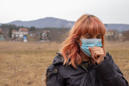 Girl with medical mask coughing. Mask to protect her from virus .Woman with mask for Coronavis....