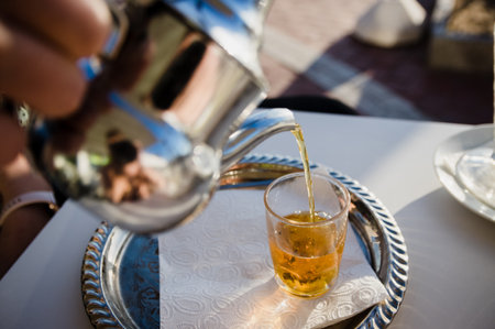 Traditional Moroccan tea pot with a cup outside ready to drinkの写真素材