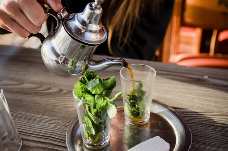 Traditional Moroccan tea pot with a cup outside ready to drink