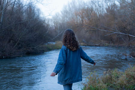 a girl in a denim jacket walks in the spring in the forestの写真素材