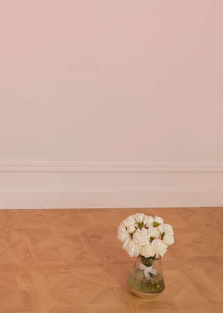 vertical photo of a wedding bouquet of white flowers in a vase with space for a signatureの写真素材
