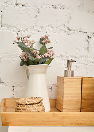 a vase with decorative flowers stands in the bathroom against a white wall