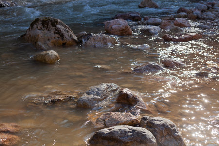 big stones in a mountain river in early springの写真素材