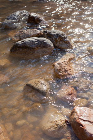 big stones in a mountain river in early springの写真素材