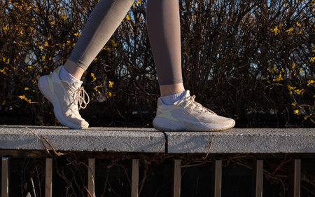 a woman in light sneakers walks in the parkの写真素材
