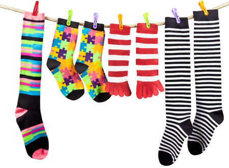 Colorful funny socks drying on the clothesline isolated on white backgroundの写真素材