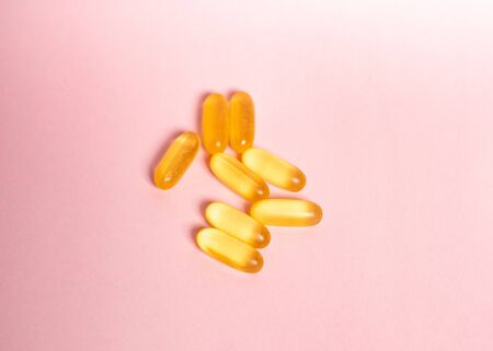 Dietary supplement omega on a pink background. Capsule fish oil on a pink background.の写真素材