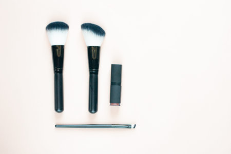 Makeup brushes and lipstick. Flat layout. Place for text.の写真素材
