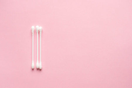 Cotton buds for cleaning ears on a pink background.