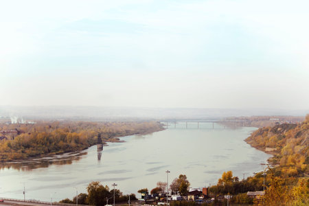 The city in the autumn season is photographed from above. River passing through the city.