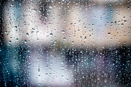 City in blur behind glass during the rain.