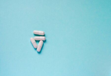 Probiotics for the stomach on a blue background. Sour milk bacteria in capsules on a blue background.の写真素材