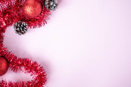 Festive decorations on a gently pink background with room for text.の写真素材