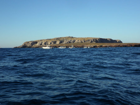 View of an island surrounded by dark blue watersの写真素材