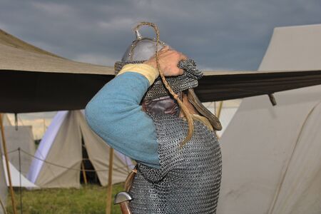 The knight puts on a helmet before a fight - a large lapの写真素材